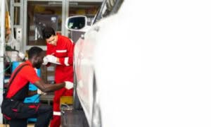 addetti in officina che effettuano la convergenza auto